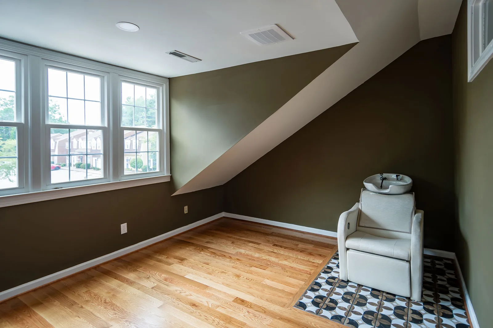 The upstairs room from the window side: chair, shampoo sink and sloped ceiling.